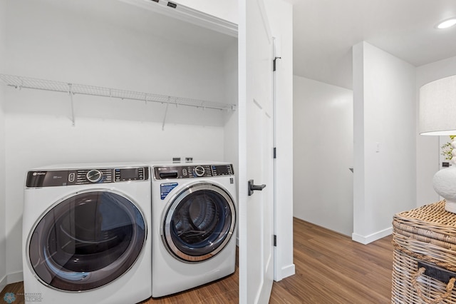 clothes washing area with wood-type flooring and washing machine and dryer