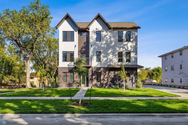 view of front of home featuring a balcony and a front lawn