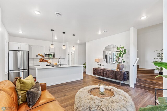 living room featuring sink and dark wood-type flooring