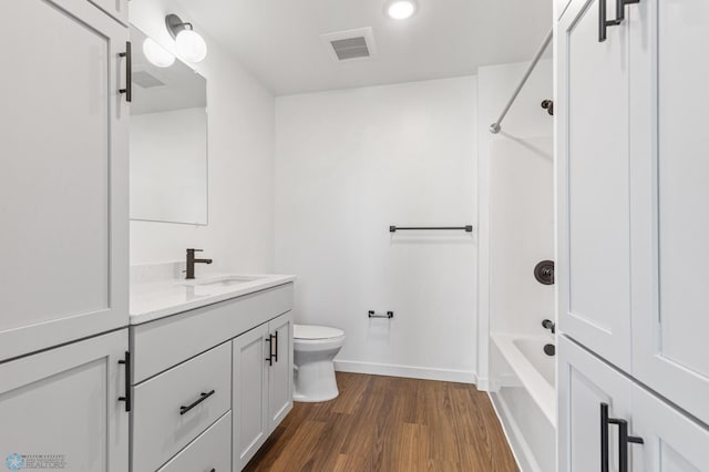 full bathroom featuring shower / bathing tub combination, hardwood / wood-style flooring, vanity, and toilet