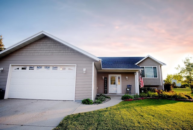 view of front of property with a yard and a garage