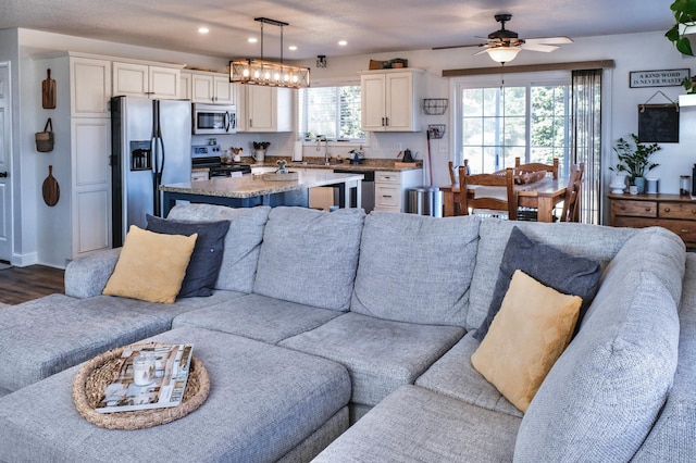 living room featuring hardwood / wood-style floors, ceiling fan, plenty of natural light, and sink