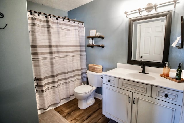 bathroom featuring vanity, a textured ceiling, hardwood / wood-style flooring, toilet, and curtained shower