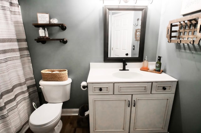 bathroom with hardwood / wood-style flooring, vanity, and toilet