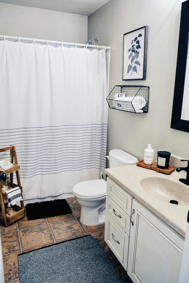 bathroom featuring tile patterned flooring, vanity, and toilet