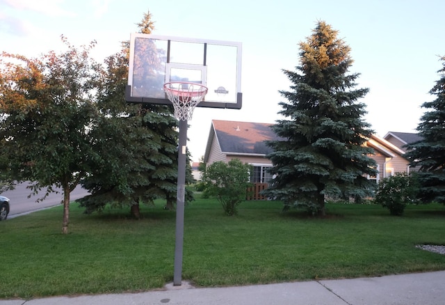 view of sport court featuring a lawn