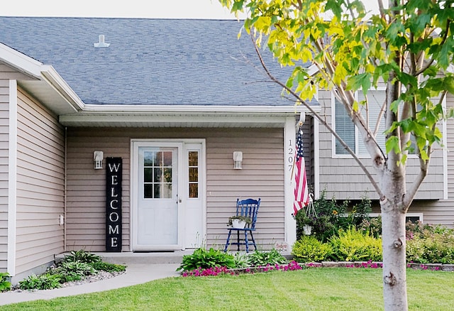 view of exterior entry with a yard