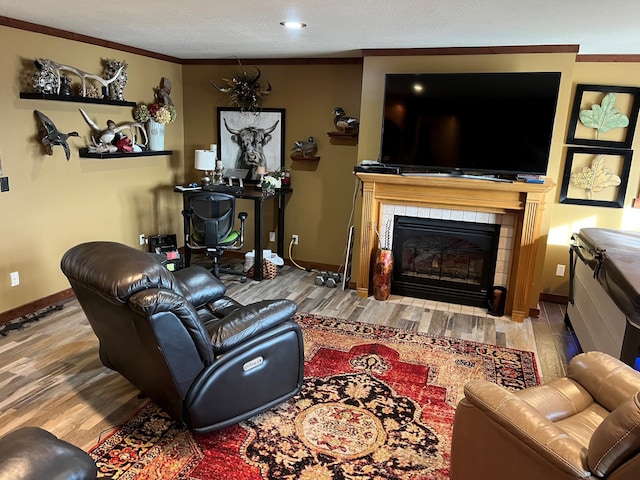 living room featuring a fireplace, wood-type flooring, and ornamental molding