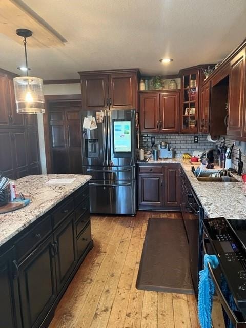 kitchen with stainless steel refrigerator with ice dispenser, decorative light fixtures, and dark brown cabinets