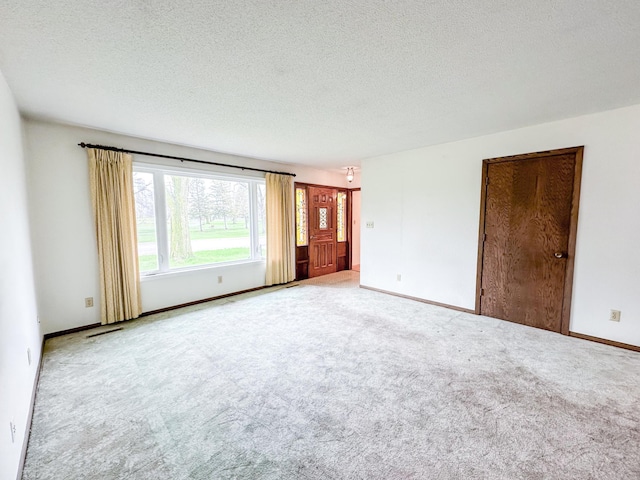 carpeted empty room featuring a textured ceiling