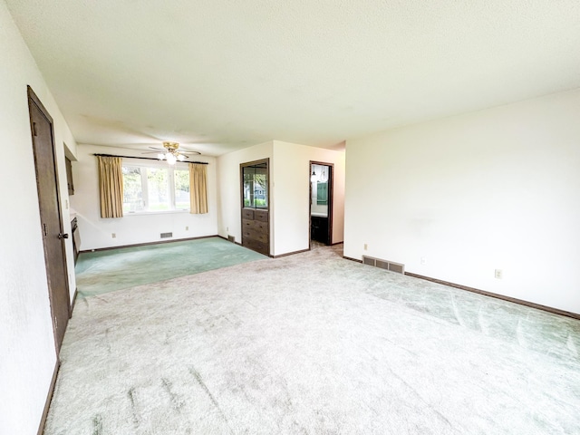 interior space with carpet, a textured ceiling, and ceiling fan