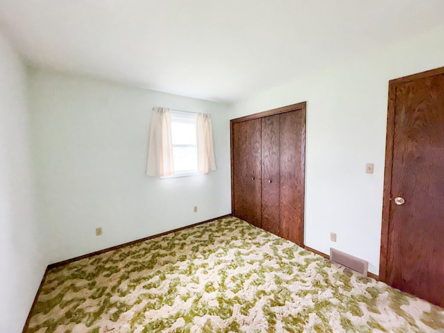 unfurnished bedroom with a closet and carpet floors