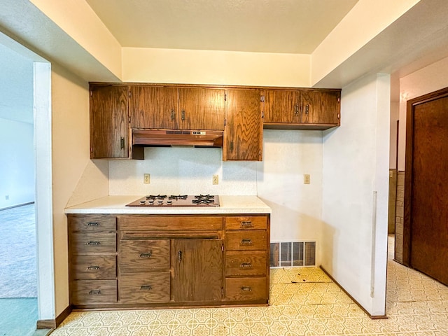 kitchen with gas cooktop and custom range hood