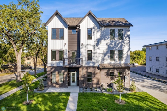 back of property featuring a balcony and a lawn