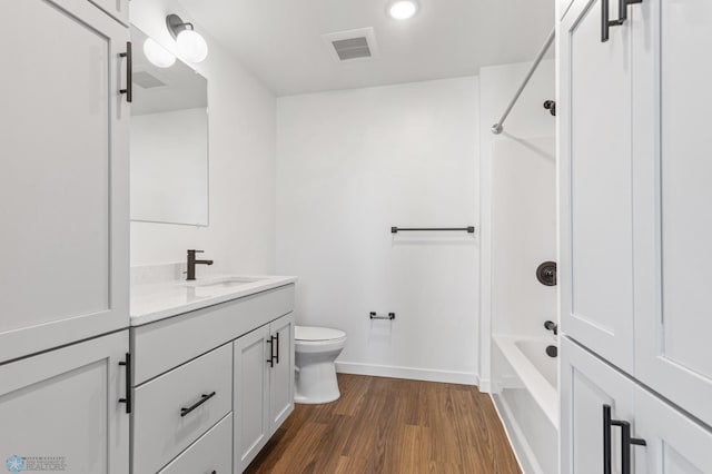 bathroom with vanity, toilet, tub / shower combination, visible vents, and wood finished floors