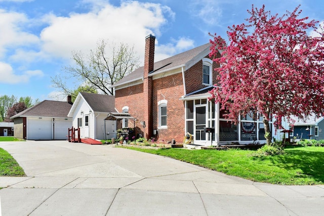 view of front facade with a sunroom, a front lawn, and a garage