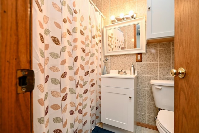 bathroom featuring tile walls, a shower with curtain, vanity, and toilet