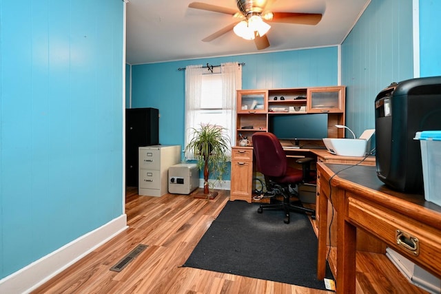 home office featuring ceiling fan, light wood-type flooring, and ornamental molding