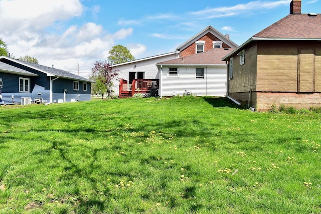 back of house with a wooden deck and a lawn