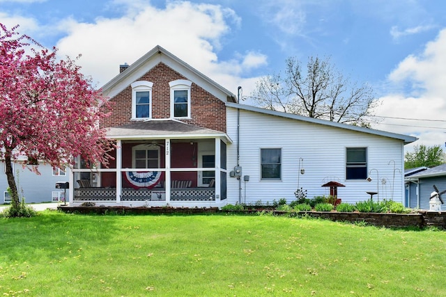 view of front of house with a sunroom and a front lawn