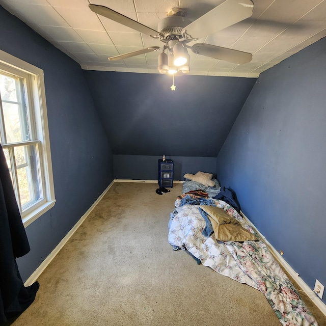 carpeted bedroom featuring ceiling fan and vaulted ceiling