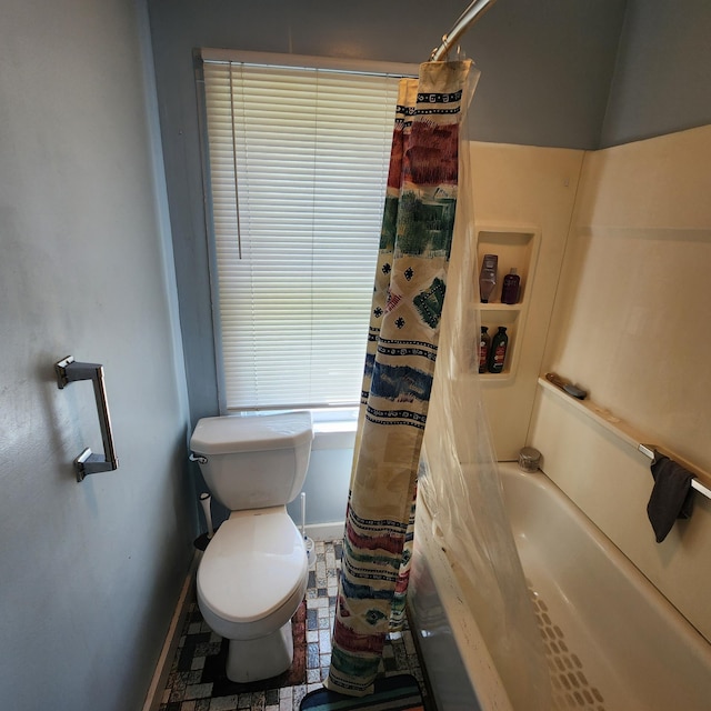 bathroom with tile flooring, toilet, and shower / tub combo with curtain