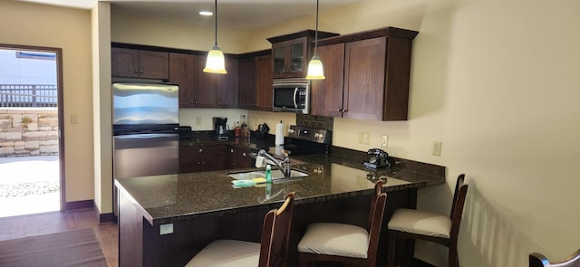 kitchen featuring plenty of natural light, kitchen peninsula, and decorative light fixtures