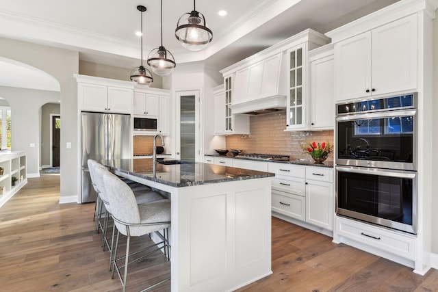 kitchen featuring an island with sink, appliances with stainless steel finishes, dark hardwood / wood-style flooring, and sink