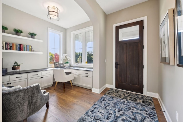 foyer entrance featuring built in desk and dark hardwood / wood-style flooring