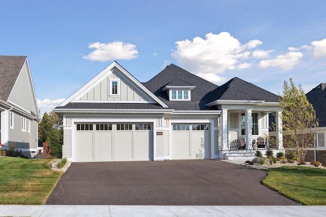 craftsman-style house featuring a garage, a porch, and a front lawn