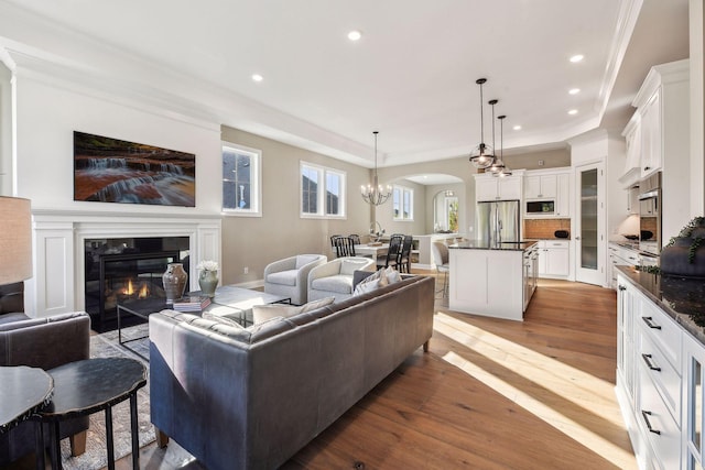 living room with a premium fireplace, crown molding, and light hardwood / wood-style flooring