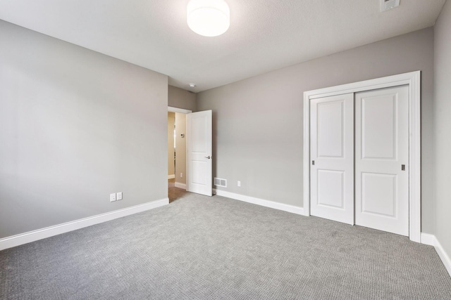 unfurnished bedroom with a closet and dark colored carpet