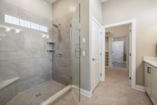 bathroom with walk in shower, vanity, and tile patterned floors