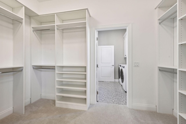 spacious closet with light carpet and independent washer and dryer