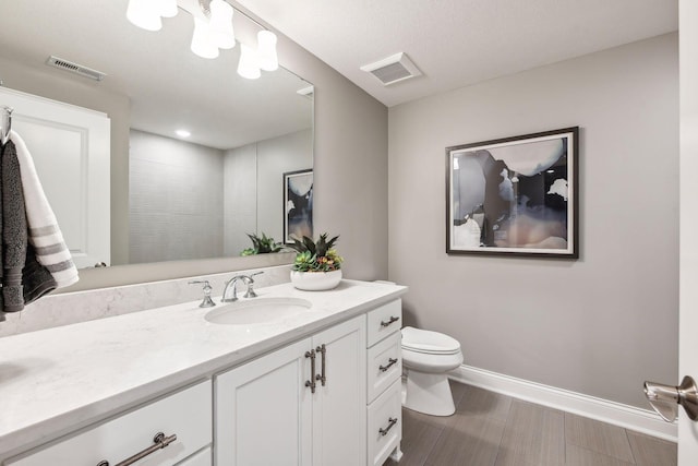 bathroom with vanity, a shower, and toilet