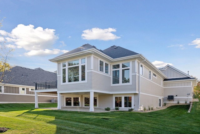 back of property featuring cooling unit and a lawn