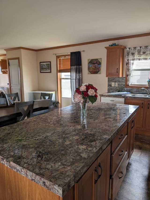 kitchen with a kitchen island, tasteful backsplash, sink, ornamental molding, and white dishwasher