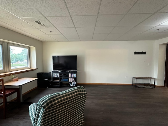 living room featuring a drop ceiling and dark hardwood / wood-style flooring