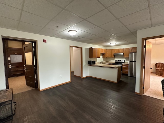 kitchen with a drop ceiling, kitchen peninsula, dark wood-type flooring, and appliances with stainless steel finishes