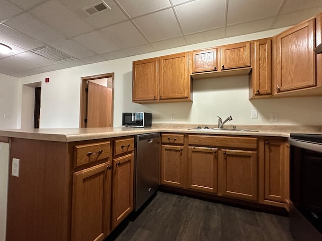 kitchen with sink, a drop ceiling, stainless steel appliances, dark hardwood / wood-style flooring, and kitchen peninsula