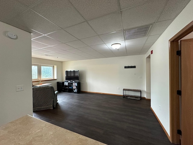 interior space featuring a paneled ceiling and dark hardwood / wood-style flooring