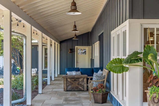 view of exterior entry with an outdoor living space, ceiling fan, and a patio