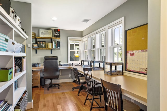 office featuring built in desk and light wood-type flooring