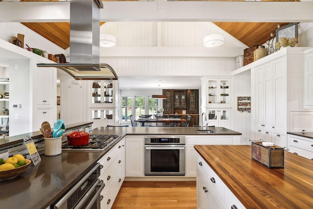 kitchen with light hardwood / wood-style flooring, island range hood, wooden ceiling, stainless steel appliances, and butcher block counters