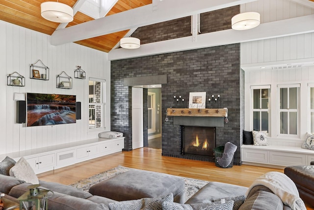 living room with a fireplace, high vaulted ceiling, light hardwood / wood-style floors, beam ceiling, and wooden ceiling