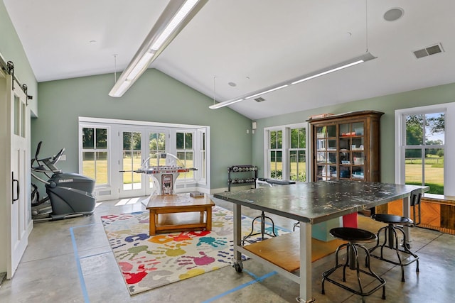 kitchen with french doors, high vaulted ceiling, a barn door, hanging light fixtures, and a center island