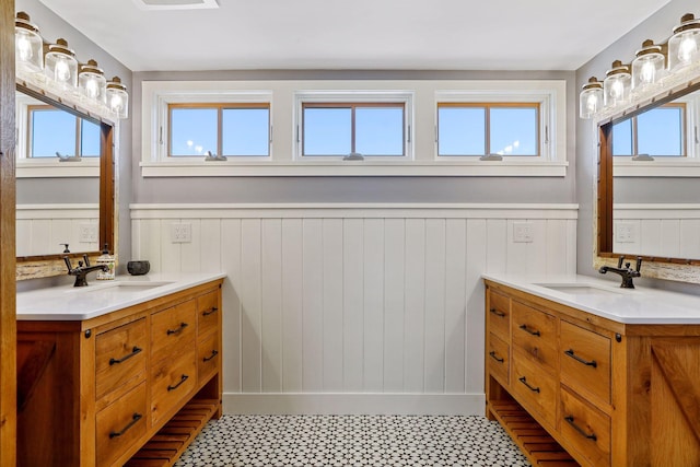 bathroom with dual sinks, vanity with extensive cabinet space, and a wealth of natural light