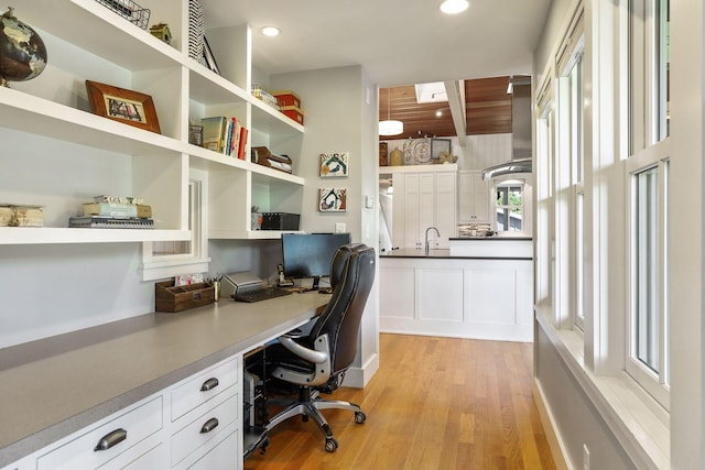 office area with wood ceiling, built in desk, light hardwood / wood-style floors, and sink