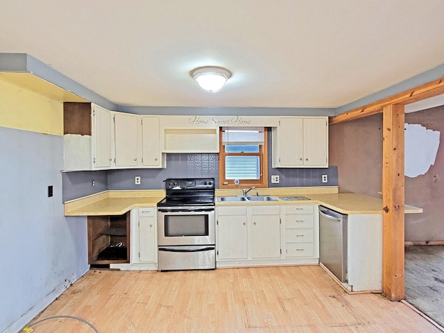 kitchen with appliances with stainless steel finishes, decorative backsplash, light wood-type flooring, and sink