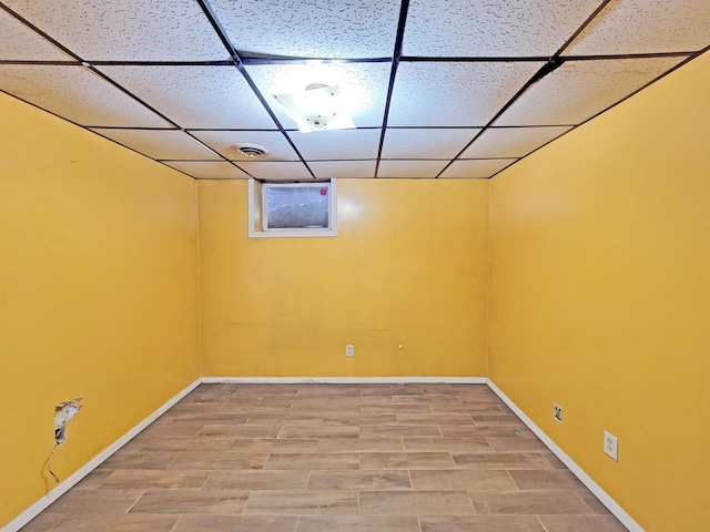 basement with hardwood / wood-style flooring and a paneled ceiling